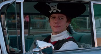 Movie still from “Fast Times at Ridgemont High” (1982), directed by Amy Heckerling – A man wearing a pirate hat sitting in the driver's seat of a car; Close Up shot, Low angle
