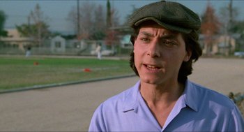 Movie still from “Fast Times at Ridgemont High” (1982), directed by Amy Heckerling – A man wearing a hat standing on a street; Close Up shot, Over the shoulder angle