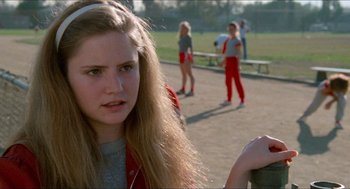 Movie still from “Fast Times at Ridgemont High” (1982), directed by Amy Heckerling – A girl is standing in a park with other girls in the background; Close Up shot, Over the shoulder angle