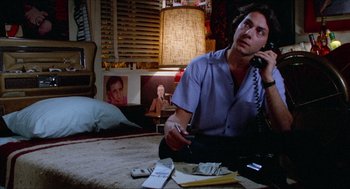 Movie still from “Fast Times at Ridgemont High” (1982), directed by Amy Heckerling – A man sitting on the floor talking on a phone; Medium shot, High angle