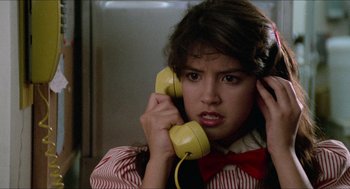 Movie still from “Fast Times at Ridgemont High” (1982), directed by Amy Heckerling – A woman holding a yellow phone up to her ear; Close Up shot, Low angle
