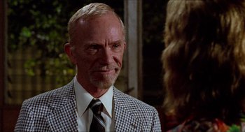 Movie still from “Fast Times at Ridgemont High” (1982), directed by Amy Heckerling – An older man wearing a suit and tie; Close Up shot, Over the shoulder angle
