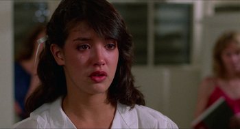 Movie still from “Fast Times at Ridgemont High” (1982), directed by Amy Heckerling – A young woman with long dark brown hair crying; Close Up shot, Over the shoulder angle