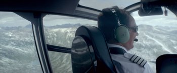 Movie still from “Ex Machina” (2014), directed by Alex Garland – A person wearing headphones is flying a plane; Medium shot, Overhead angle