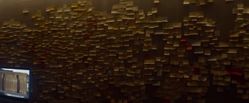 Movie still from “Ex Machina” (2014), directed by Alex Garland – A wall covered in many different colored sticky notes; Medium shot, High angle