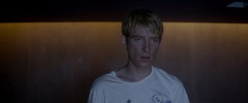 Movie still from “Ex Machina” (2014), directed by Alex Garland – A man with blonde hair and a white t - shirt; Close Up shot, Over the shoulder angle