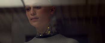 Movie still from “Ex Machina” (2014), directed by Alex Garland – A woman wearing a neck brace is standing in front of a mirror; Close Up shot, Over the shoulder angle