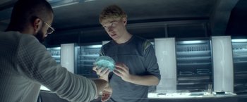 Movie still from “Ex Machina” (2014), directed by Alex Garland – A man is holding something in his hands; Close Up shot, Over the shoulder angle