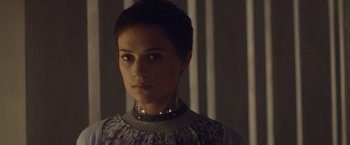 Movie still from “Ex Machina” (2014), directed by Alex Garland – A woman wearing a collar and a necklace; Close Up shot, Over the shoulder angle