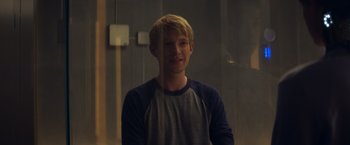 Movie still from “Ex Machina” (2014), directed by Alex Garland – A young man standing in front of a wall; Medium shot, Over the shoulder angle