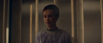 Movie still from “Ex Machina” (2014), directed by Alex Garland – A woman with short black hair wearing a necklace; Close Up shot, Over the shoulder angle