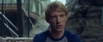 Movie still from “Ex Machina” (2014), directed by Alex Garland – A man with blonde hair wearing a blue shirt; Close Up shot, Over the shoulder angle