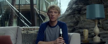 Movie still from “Ex Machina” (2014), directed by Alex Garland – A young man holding a bottle of beer in his hand; Close Up shot, Over the shoulder angle