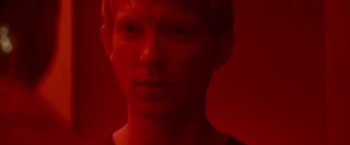 Movie still from “Ex Machina” (2014), directed by Alex Garland – A young man with red hair is looking at the camera; Close Up shot, Overhead angle