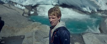Movie still from “Ex Machina” (2014), directed by Alex Garland – A young man standing in front of a body of water; Close Up shot, High angle