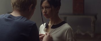 Movie still from “Ex Machina” (2014), directed by Alex Garland – A young woman looking at a man in a room; Close Up shot, Over the shoulder angle