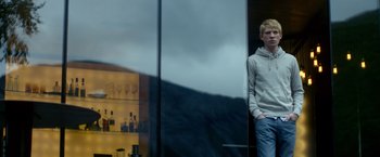 Movie still from “Ex Machina” (2014), directed by Alex Garland – A young man standing in front of a store window; Medium shot, Low angle