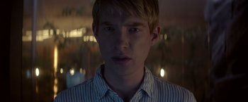 Movie still from “Ex Machina” (2014), directed by Alex Garland – A young man with blonde hair and a striped shirt; Close Up shot, Over the shoulder angle