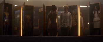 Movie still from “Ex Machina” (2014), directed by Alex Garland – A man and a woman standing next to each other in front of a mirror; Medium shot, Over the shoulder angle
