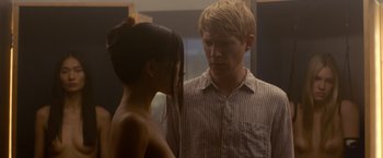 Movie still from “Ex Machina” (2014), directed by Alex Garland – A man and a woman standing next to each other in front of a mirror; Medium shot, Over the shoulder angle