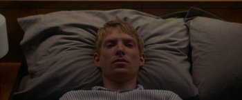 Movie still from “Ex Machina” (2014), directed by Alex Garland – A man laying in a bed with his head on a pillow; Close Up shot, Overhead angle