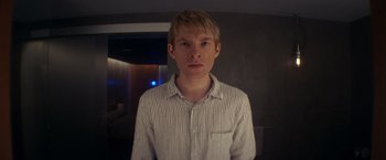 Movie still from “Ex Machina” (2014), directed by Alex Garland – A man in a striped shirt is looking at the camera; Close Up shot, Low angle