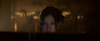 Movie still from “Ex Machina” (2014), directed by Alex Garland – A woman with a yellow hairpiece looking at the camera; Close Up shot, Low angle