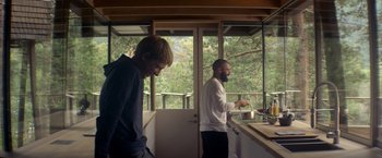 Movie still from “Ex Machina” (2014), directed by Alex Garland – Two men are standing in a kitchen preparing a meal; Medium shot, Low angle