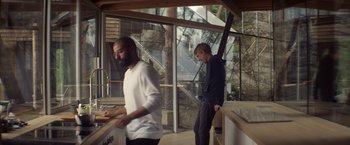 Movie still from “Ex Machina” (2014), directed by Alex Garland – Two men standing in front of a kitchen sink; Wide shot, Low angle