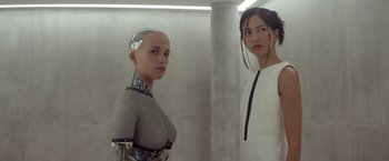 Movie still from “Ex Machina” (2014), directed by Alex Garland – Two women standing next to each other in front of a wall; Medium shot, Low angle