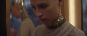 Movie still from “Ex Machina” (2014), directed by Alex Garland – A person with a collar and a necklace on; Close Up shot, Low angle