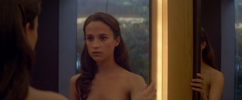Movie still from “Ex Machina” (2014), directed by Alex Garland – A woman with long brown hair looking into a bathroom mirror; Close Up shot, Over the shoulder angle
