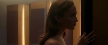Movie still from “Ex Machina” (2014), directed by Alex Garland – A woman with long brown hair standing in front of a mirror; Close Up shot, Over the shoulder angle