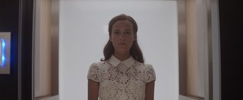 Movie still from “Ex Machina” (2014), directed by Alex Garland – A woman in a white dress is looking at the camera; Close Up shot, Low angle