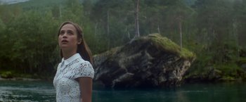 Movie still from “Ex Machina” (2014), directed by Alex Garland – A woman standing in front of a body of water; Medium shot, Low angle