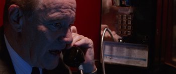 Movie still from “Glengarry Glen Ross” (1992), directed by James Foley – An older man talking on a phone in front of a pay phone; Close Up shot, High angle