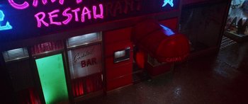 Movie still from “Glengarry Glen Ross” (1992), directed by James Foley – An overhead view of a restaurant at night with neon lights; Extreme Wide shot, Overhead angle