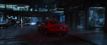 Movie still from “Glengarry Glen Ross” (1992), directed by James Foley – A red car parked on the side of the street; Wide shot, High angle