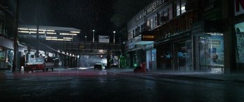 Movie still from “Glengarry Glen Ross” (1992), directed by James Foley – A city street at night in the rain; Extreme Wide shot, High angle