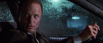 Movie still from “Glengarry Glen Ross” (1992), directed by James Foley – A man in a suit sitting in the back of a car; Close Up shot, Low angle