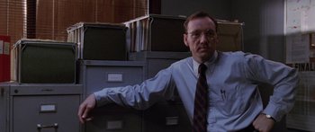 Movie still from “Glengarry Glen Ross” (1992), directed by James Foley – A man standing in front of a bunch of filing cabinets; Medium shot, Low angle