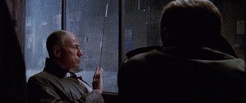 Movie still from “Glengarry Glen Ross” (1992), directed by James Foley – A man sitting in front of a window in the rain; Close Up shot, Over the shoulder angle