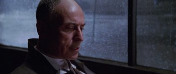 Movie still from “Glengarry Glen Ross” (1992), directed by James Foley – An older man in a suit and tie looking to his left; Close Up shot, Low angle