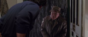 Movie still from “Glengarry Glen Ross” (1992), directed by James Foley – An older man wearing a hat talking to a younger man; Medium shot, Over the shoulder angle