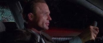 Movie still from “Glengarry Glen Ross” (1992), directed by James Foley – A person sitting in a car; Close Up shot, Over the shoulder angle