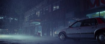 Movie still from “Glengarry Glen Ross” (1992), directed by James Foley – A car parked on the side of the road in the rain; Extreme Wide shot, Low angle