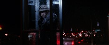 Movie still from “Glengarry Glen Ross” (1992), directed by James Foley – A man wearing a hat is talking on a phone; Close Up shot, Over the shoulder angle
