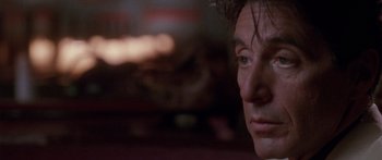 Movie still from “Glengarry Glen Ross” (1992), directed by James Foley – A man's face in a dark room; Close Up shot, Over the shoulder angle