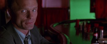 Movie still from “Glengarry Glen Ross” (1992), directed by James Foley – A person sitting at a table; Close Up shot, Over the shoulder angle