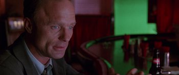 Movie still from “Glengarry Glen Ross” (1992), directed by James Foley – A person sitting at a table; Close Up shot, Over the shoulder angle